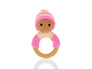Pink wooden & crochet teething ring rattles. The wood ring is half wrapped with crocheted cotton, a cute head sits on top of the wooden ring with stitched black eyes and a matching bobby hat