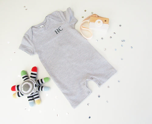 Baby all in one bodysuit. grey & white stripe with envelope neck and popper fastening around the legs.